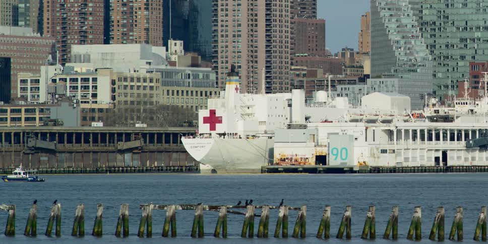 A river with boats and ships with buildings and skyscrapers in the background