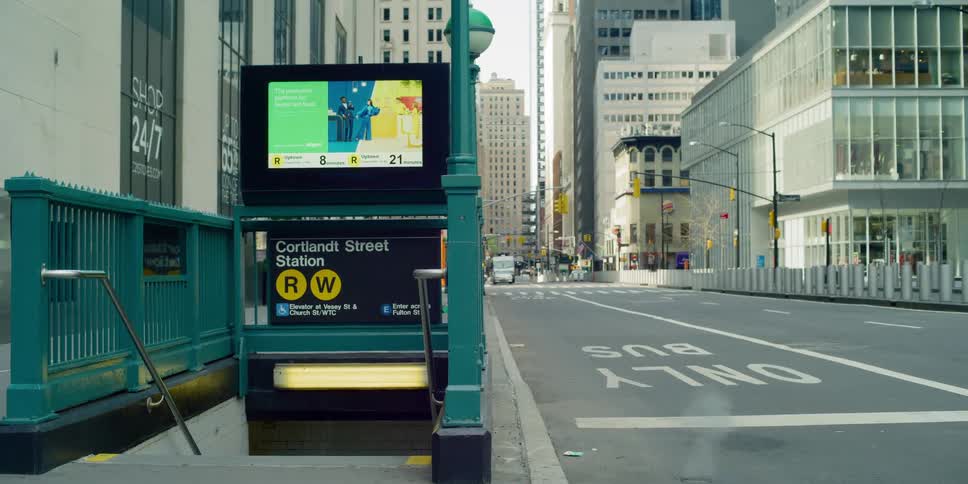 A city street with a subway staircase entrance