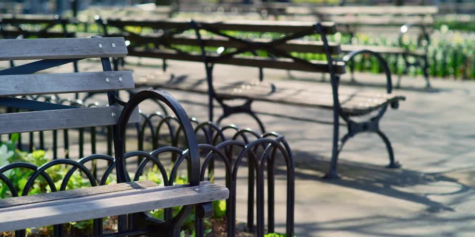 Park benches with people walking in the background