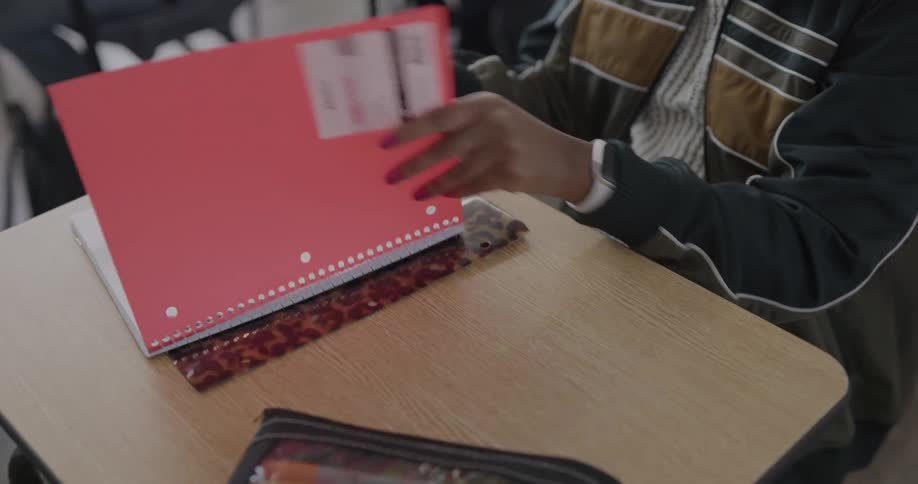 A student pulls out a notebook in a classroom