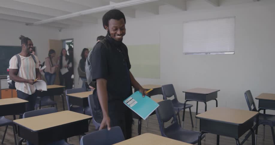 Teacher waiting for students greets them as they enter the classroom