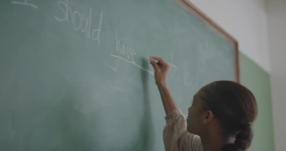 A student writes on a chalkboard
