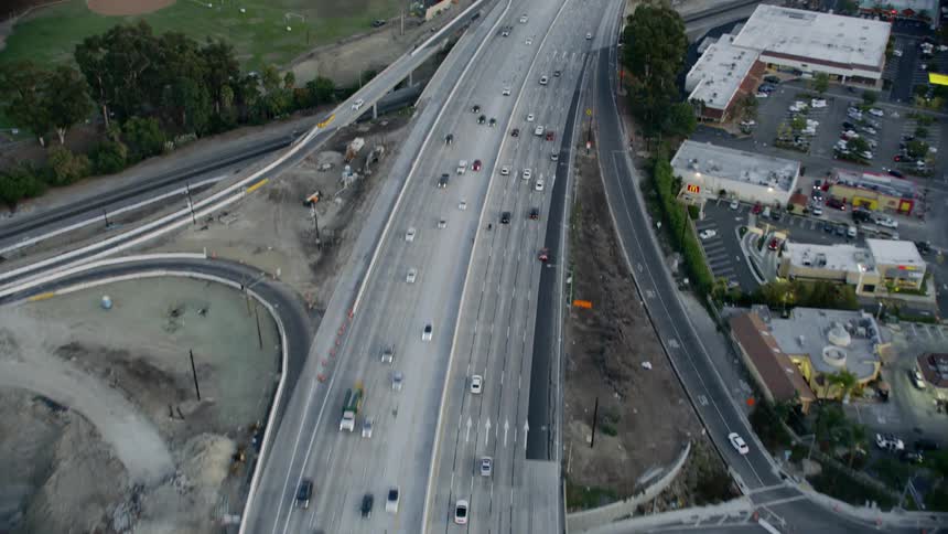 A highway with vehicles buildings and trees