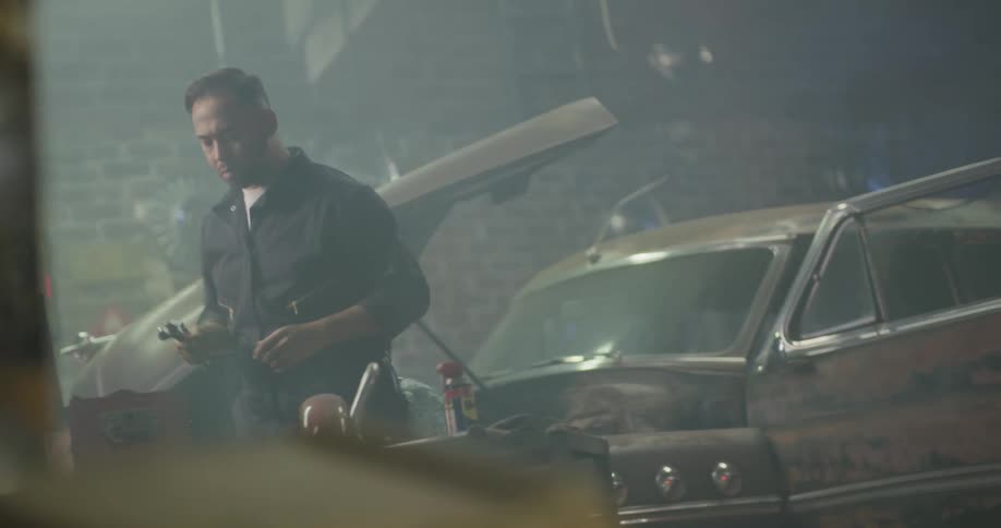 Mechanic working on a vintage car in a body shop