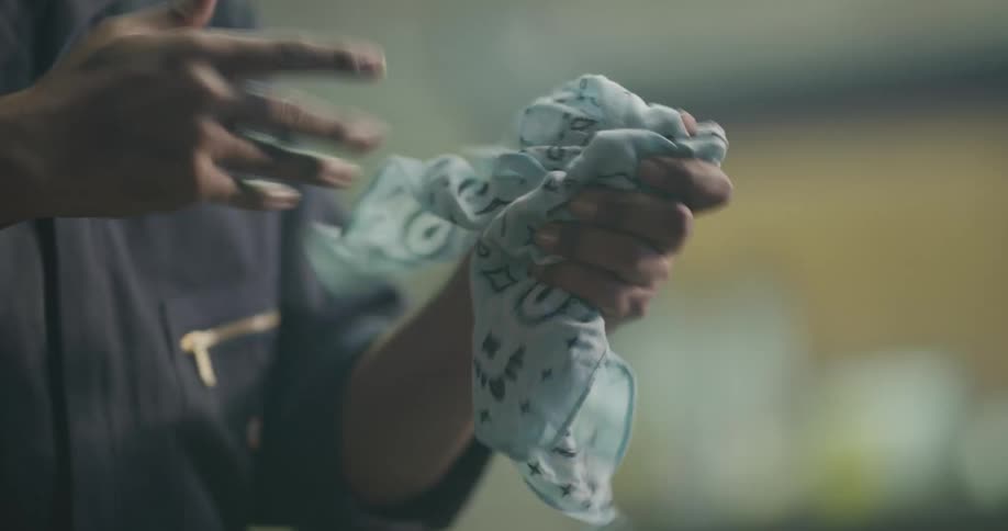 A mechanic wiping off his hands with a blue bandana