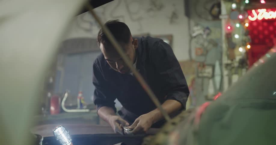 A man is working on a car in a garage