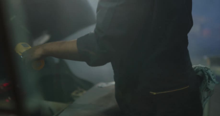 Mechanic working on a car engine in workshop