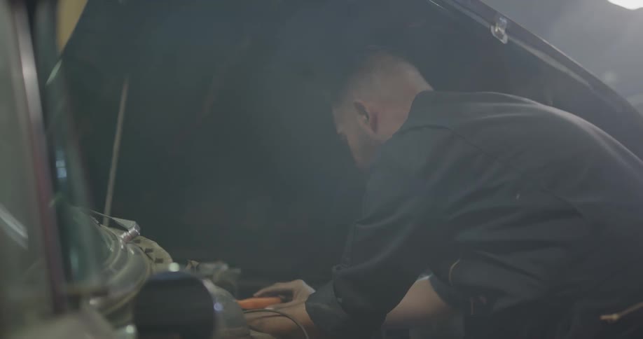 A mechanic works on a car
