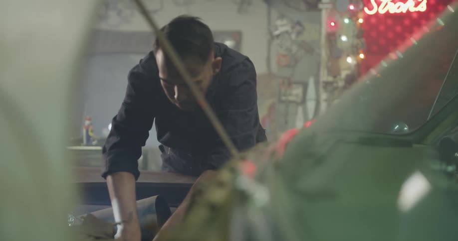 A mechanic in a garage working on a car engine