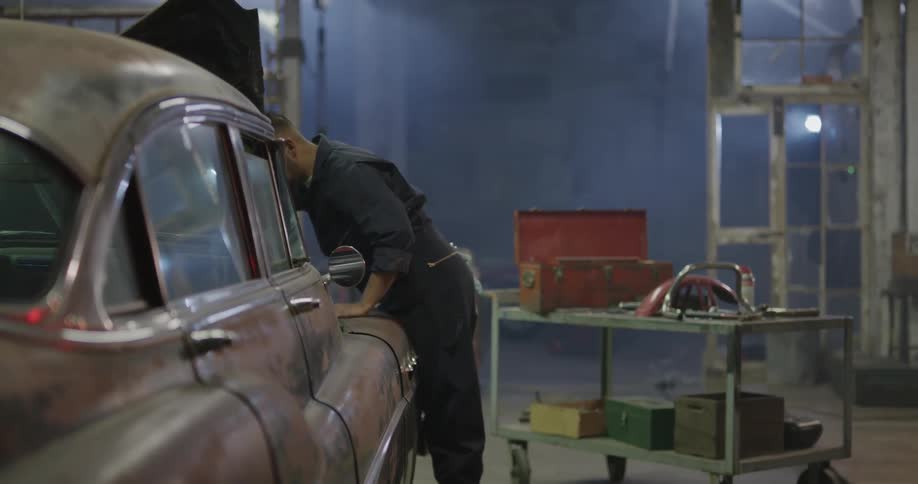 A man is working on a car in a garage
