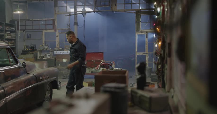A mechanic working on an old car