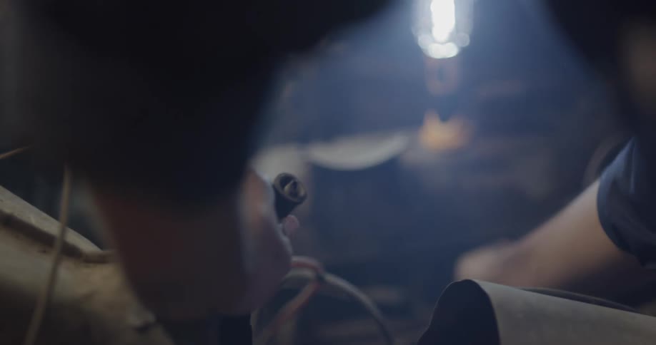 Car mechanic examines wires in engine