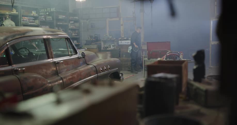 A mechanic walking around in a garage