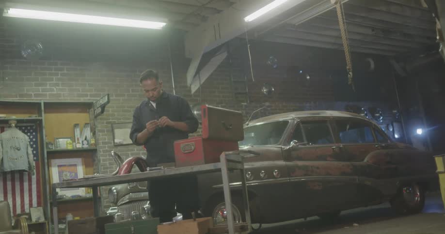 A mechanic disassembling a part next to a toolbox