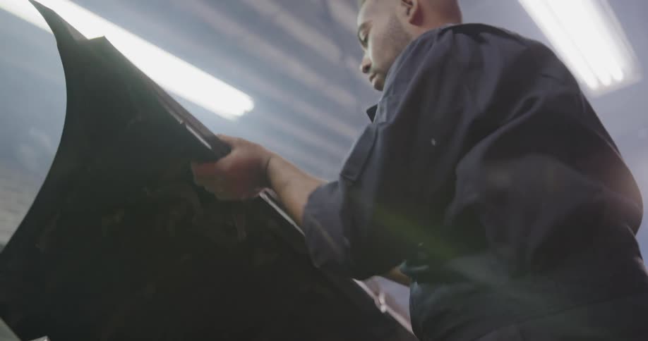 The mechanic closes the hood