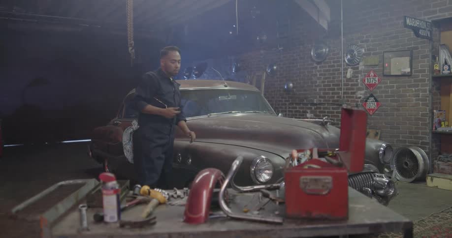 A mechanic finishes working on a car