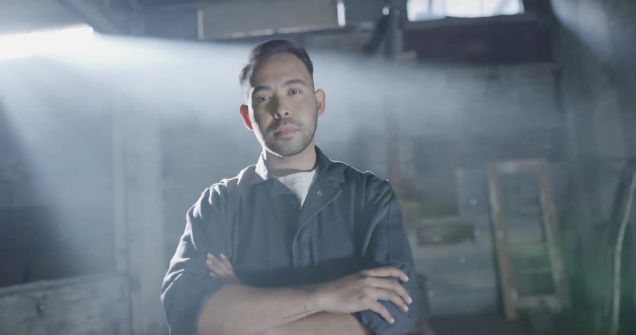 A guy is smiling in a garage