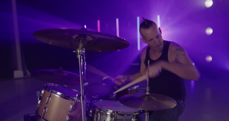 Drummer performs on stage with rock band