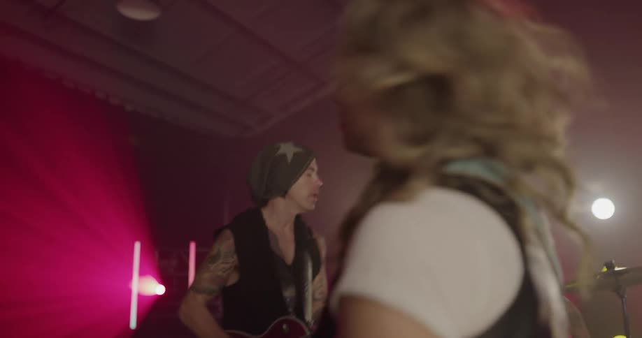 A band with three guitarists and a drummer perform on stage