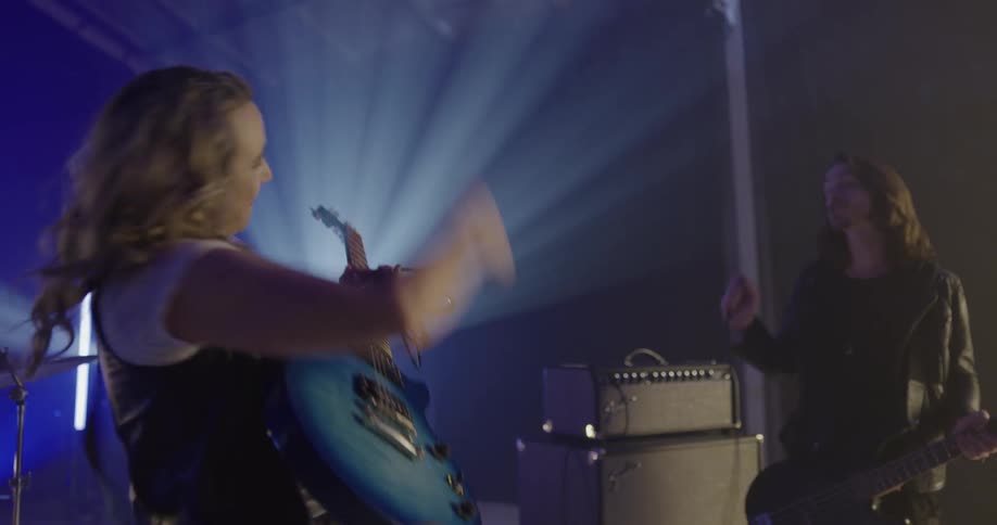 A group of musicians plug in their instruments in a large stage or studio