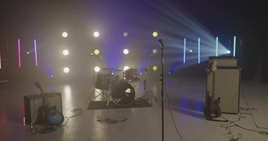 Music equipment on a stage with lights in the background