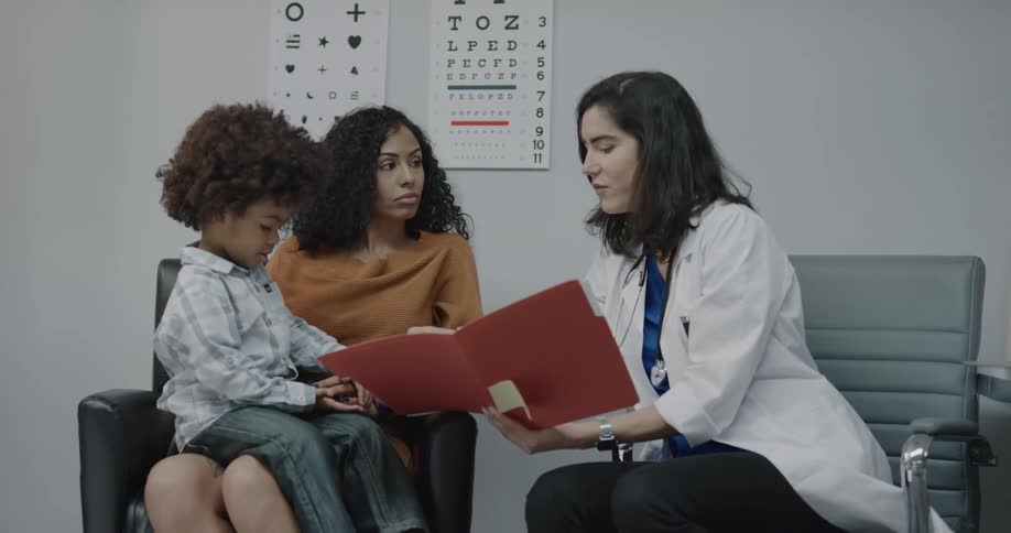 Ophthalmologist talking to a mother and his son in her office