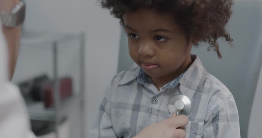 Doctor checks boys health using stethoscope