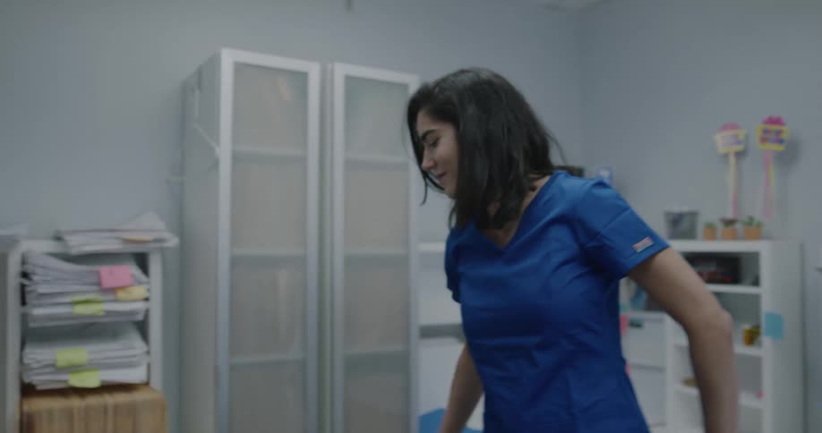 A doctor taking off her coat