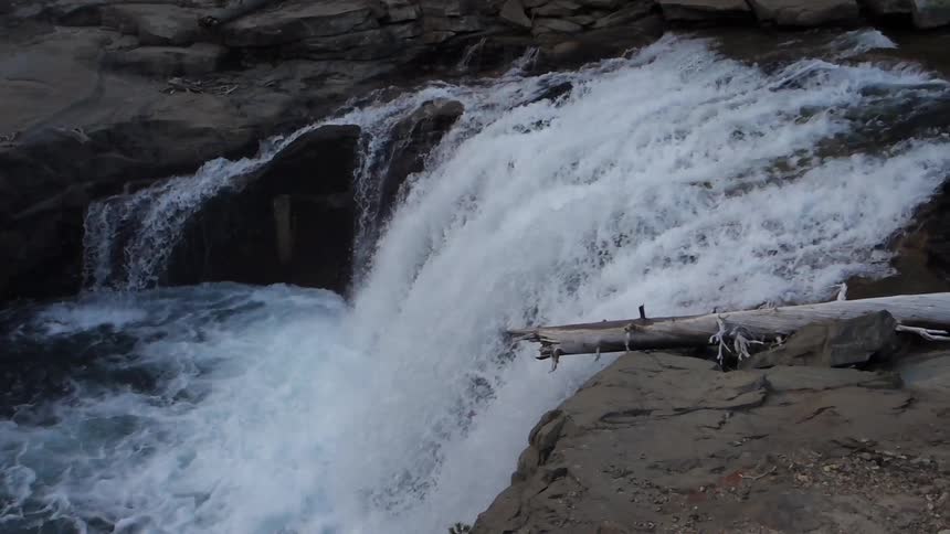 River water gushes over a small cliff