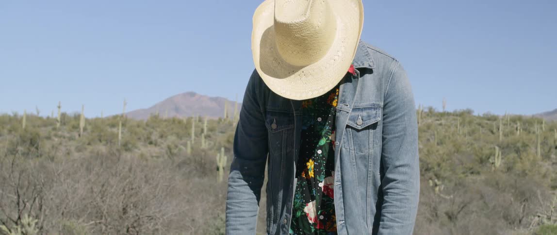 A person standing in a field with their head down