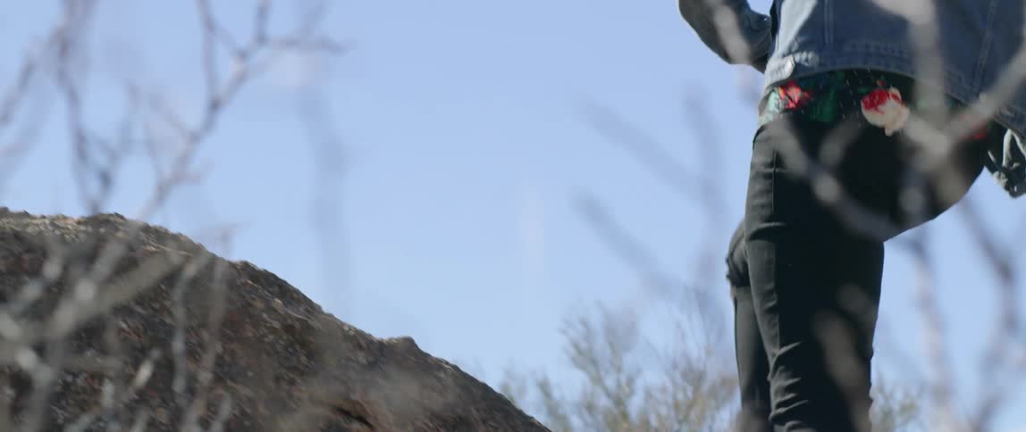 A running person doing a small jump to climb a boulder