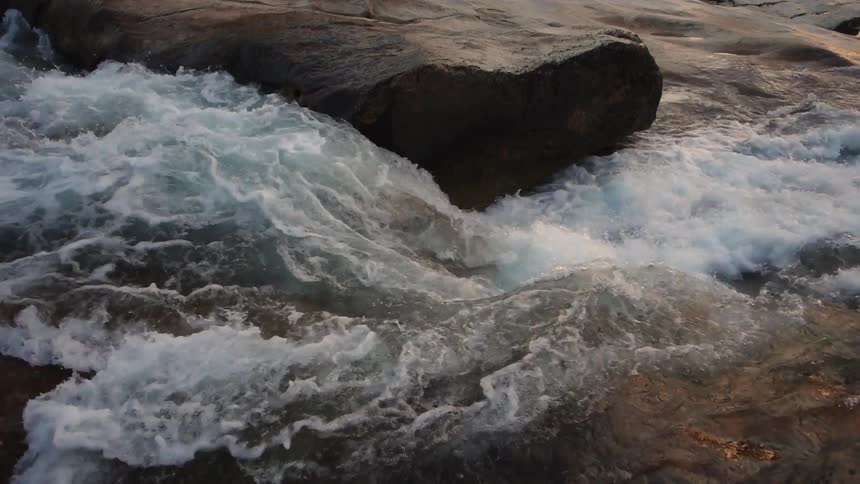 Water in a stream flows over rocks