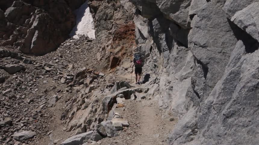 A hiker moves up a mountain path