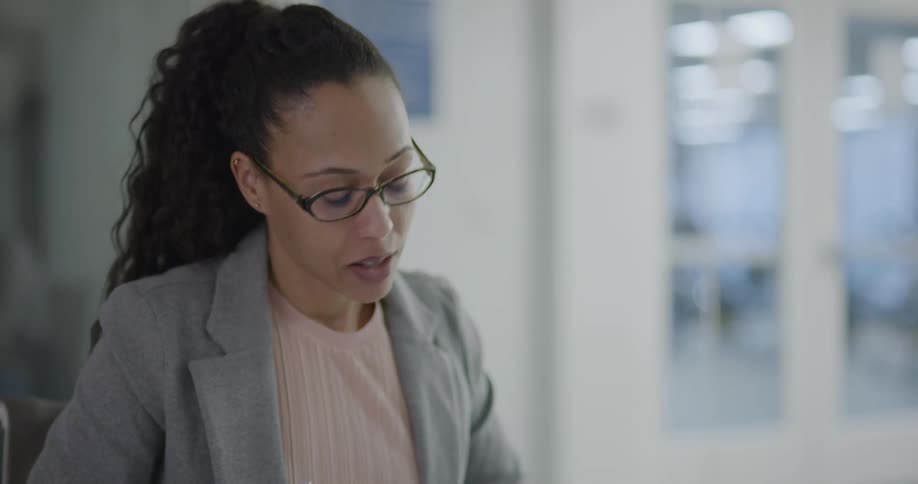 Businesswoman sitting at the table writes down and talks to the coworkers