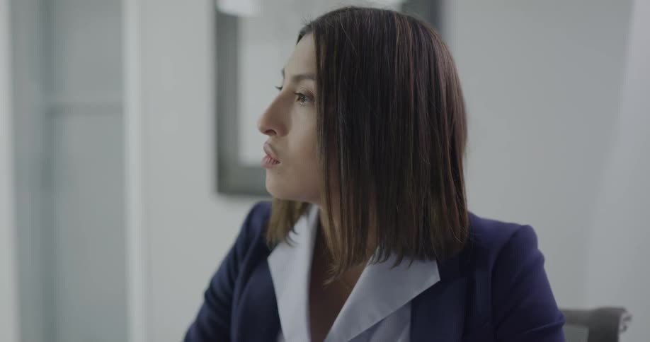 A woman sitting at a desk in an office talking
