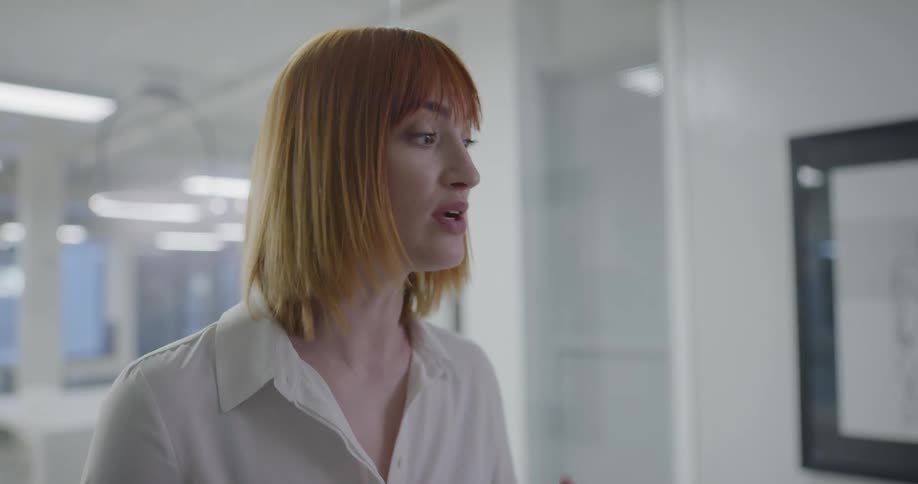 A woman in an office talks to other people