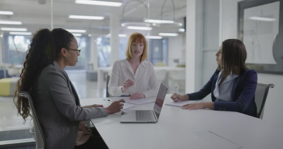Women sitting in an office talking and writing