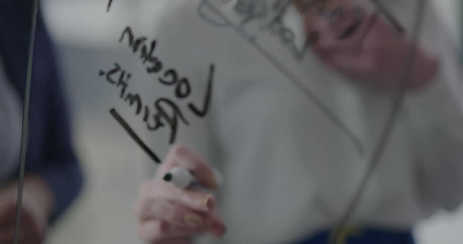 Two women discussing a whiteboard drawing
