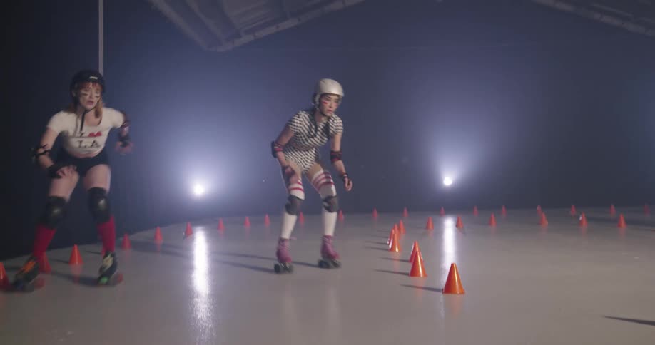 Women with helmets roller skating indoors