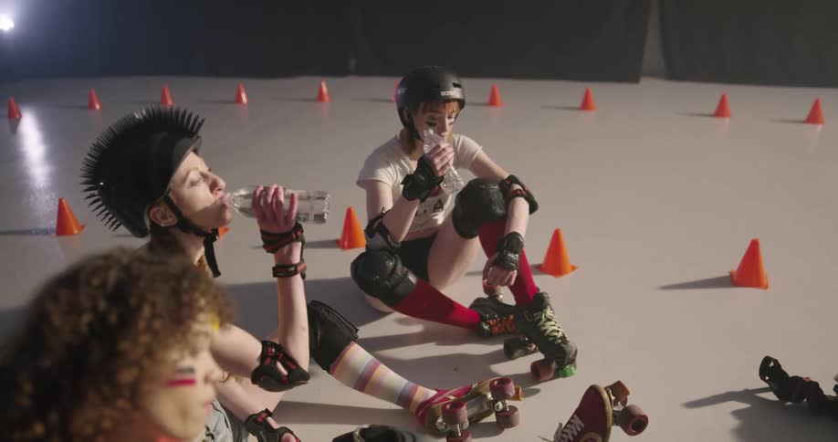 A group of women with rollerblades drinking water