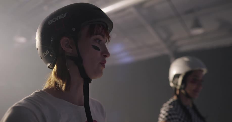 Two women with helmets standing and talking