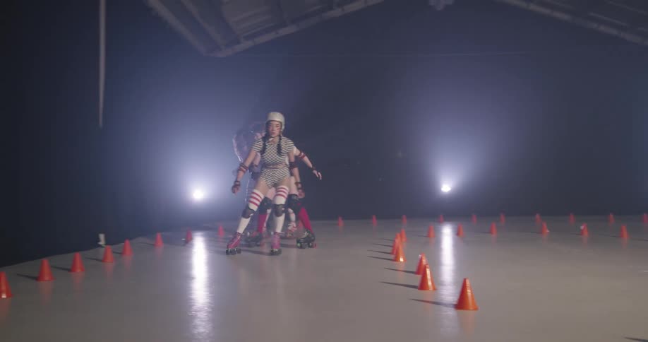 Women with helmets roller skating indoors