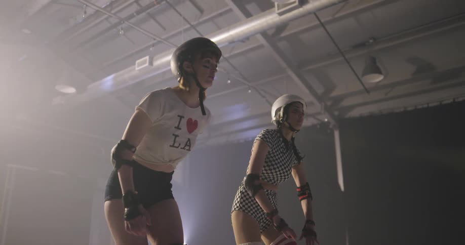 Two women get ready for roller skating indoors