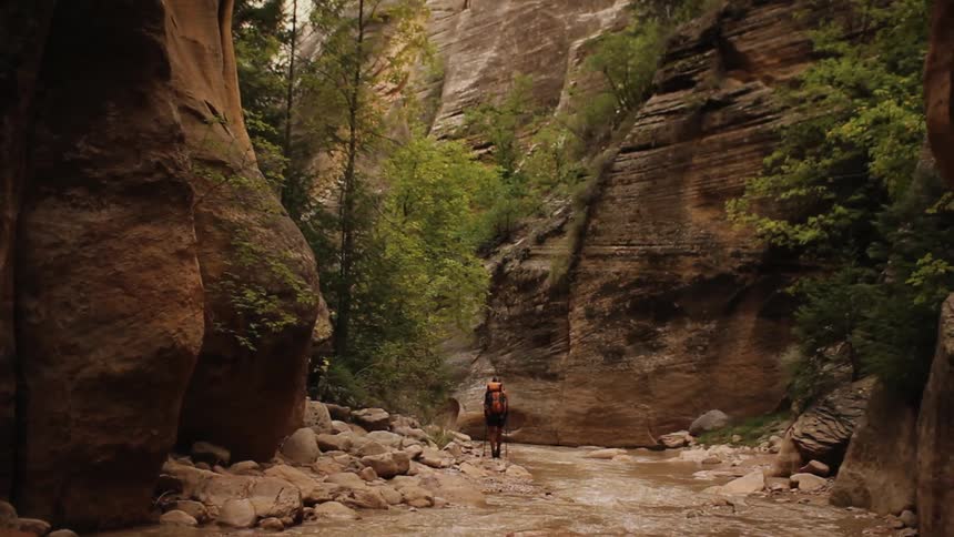 A man is hiking in between two mountains