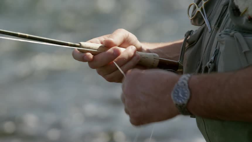 A fisherman pulls on a fishing line