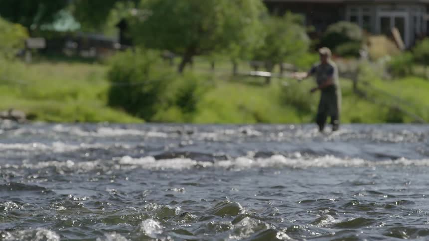 Fisherman casts his line in a stream