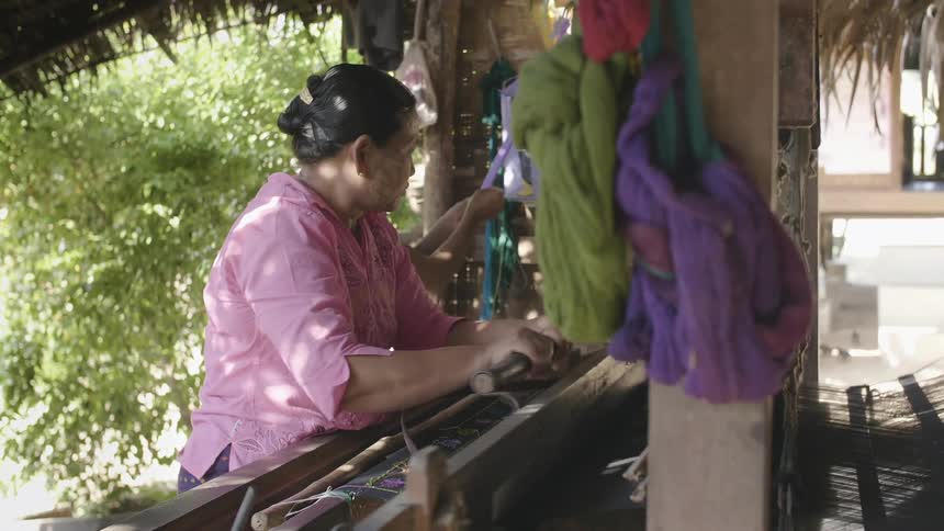 A woman works a loom