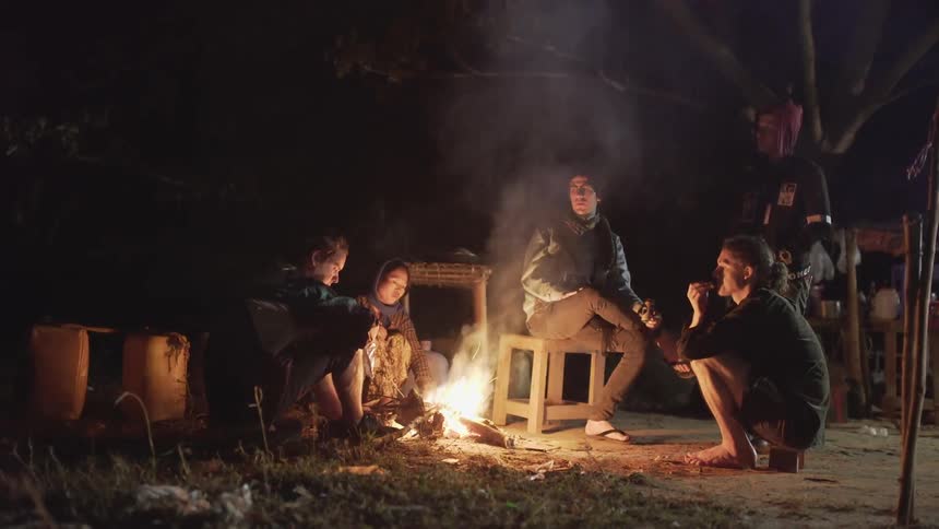 People gathered around a campfire talking