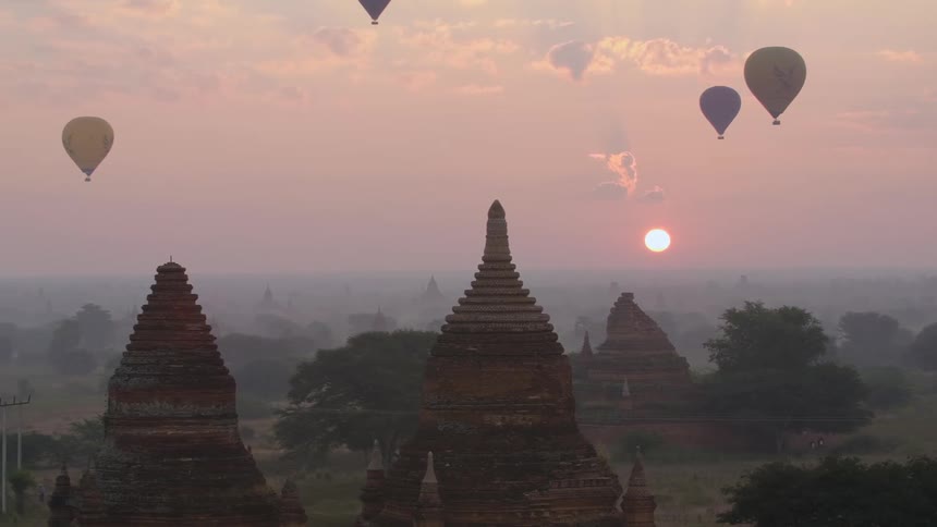 Many hot air balloons sit in the sky