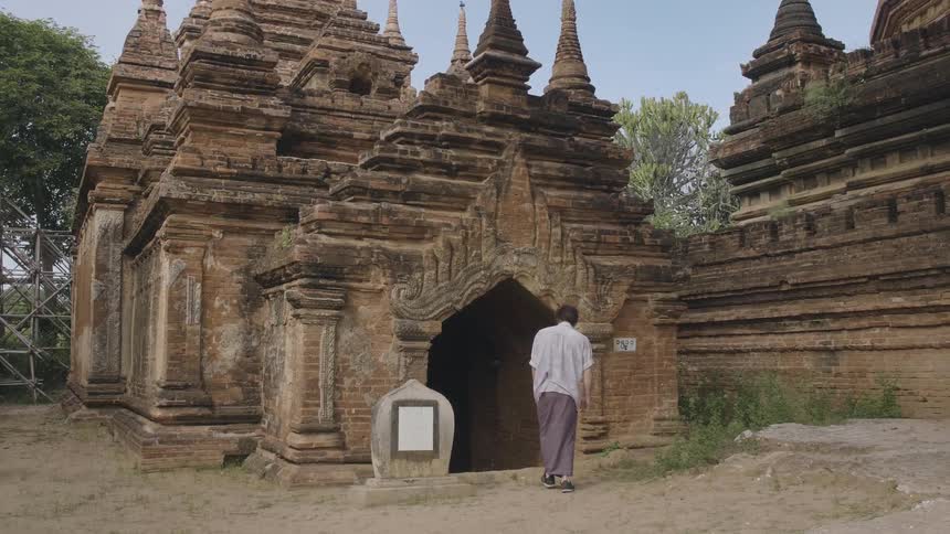 A woman walks in to an old stone building
